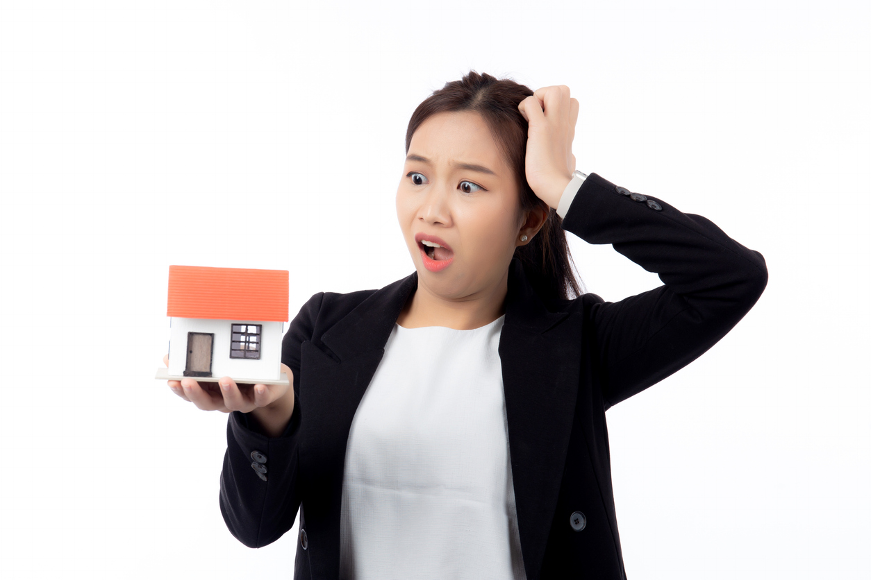Portrait young asian businesswoman unhappy about loan of montage home isolated white background, expression and emotion, business woman annoyed and worried with debt house, stress and depressed.